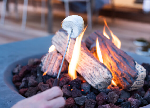 Marshmallows am Feuertisch auf der Terrasse rösten