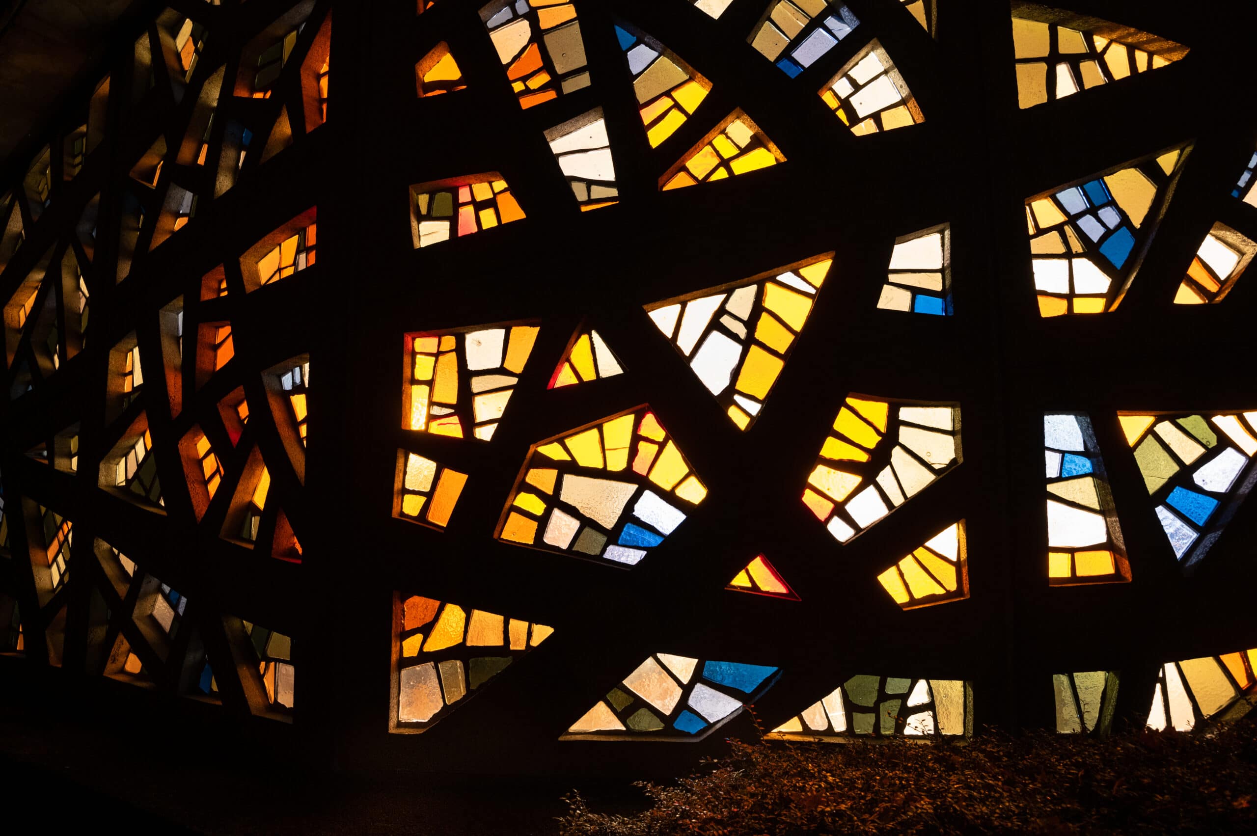 From inside, the lights shine through the colorful glass of the chapel.