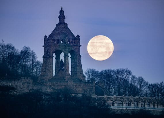 Full moon setting behind the Kaiser Wilhelm Monument in Porta Westfalica
