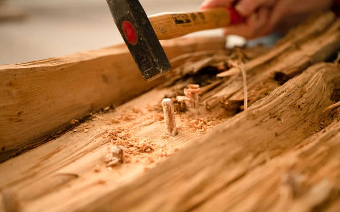 The mushroom dowels are hammered into the logs.